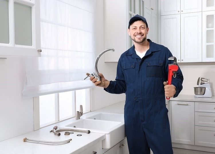 Qualified plumber replacing sink tapware as part of plumbing regulations